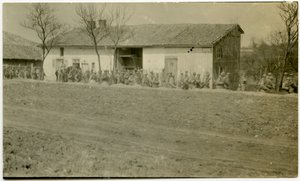 A Group of Soldiers Marching Past a House Next to a Dirt Road by Carl Michel